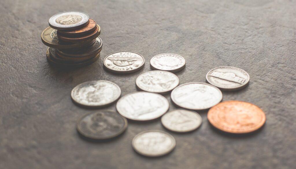 verschillende-soorten-munten-op-een-grijze-tafel